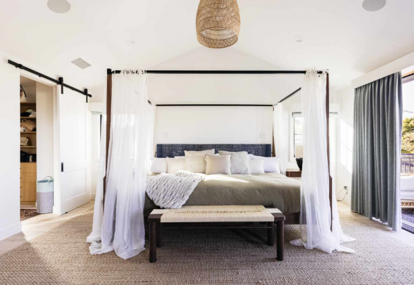 Kamar dengan tempat tidur di tengah ruangan, dikelilingi oleh tirai mewah